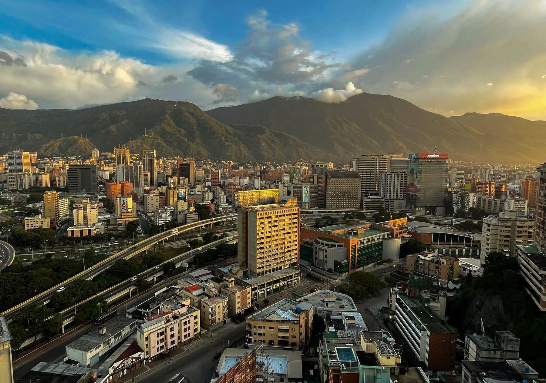 Vista aérea de Caracas, rodeada de montañas al atardecer