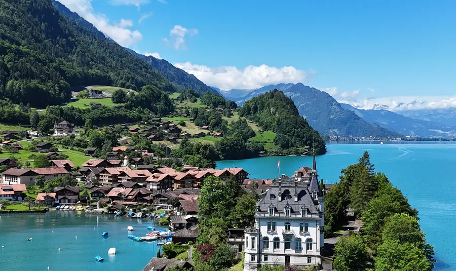 Villa en una isla de un lago turquesa, rodeada por los Alpes suizos