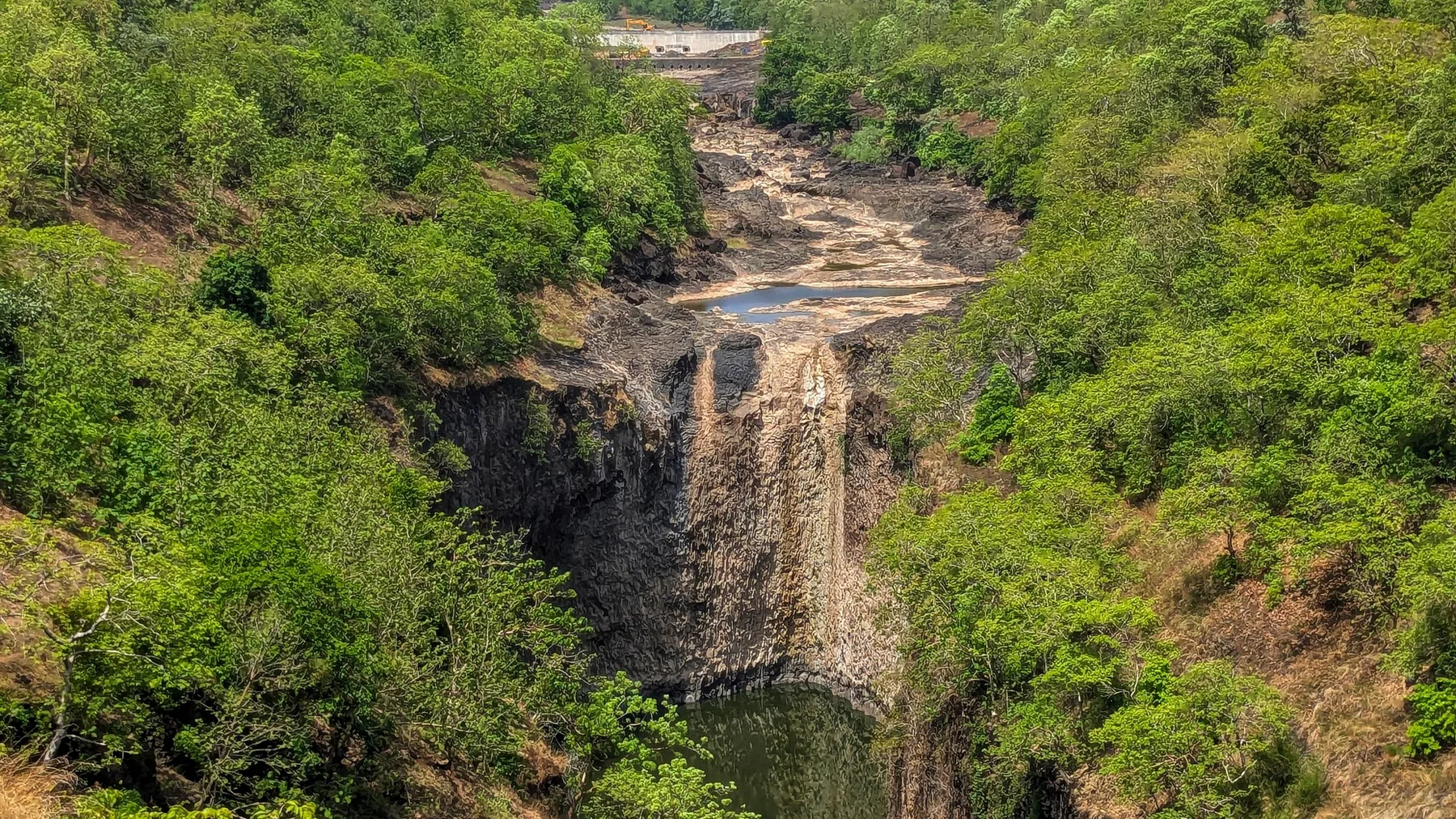 Valle exuberante con una cascada que cae en un desfiladero