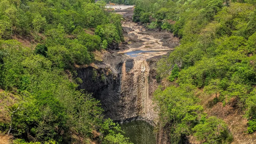 Valle exuberante con una cascada que cae en un desfiladero