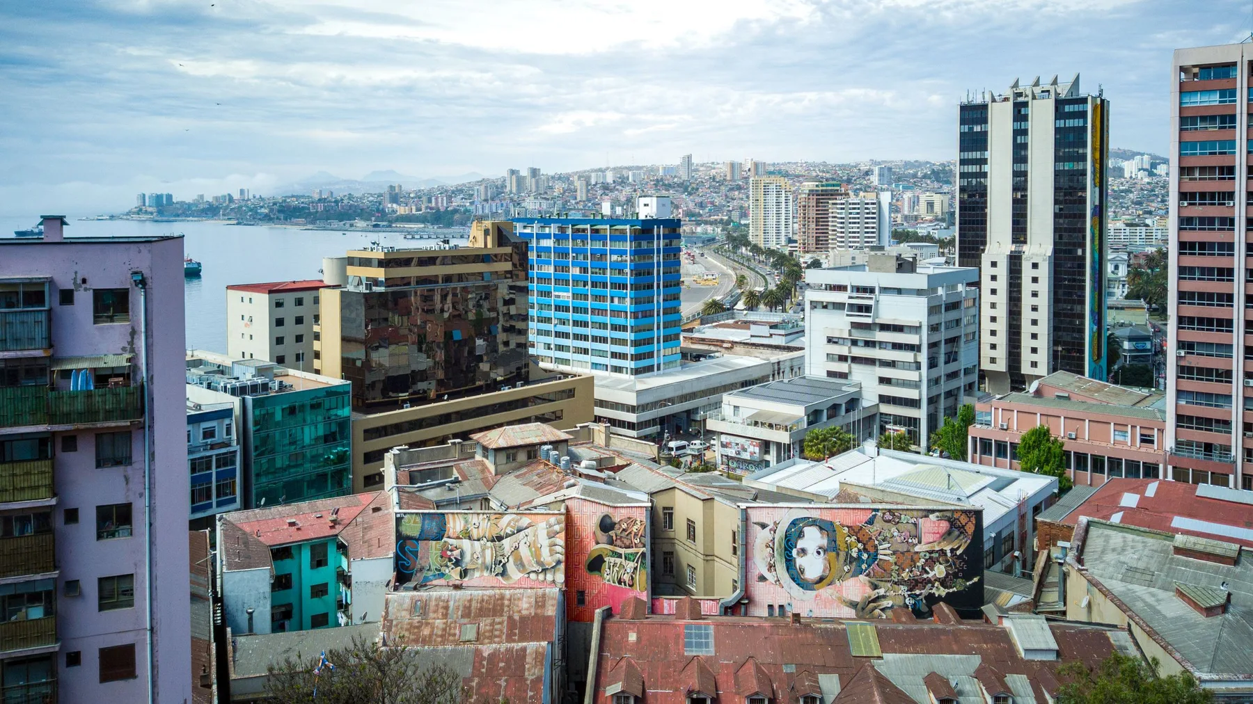 Vista de Valparaíso con cerros, edificios coloridos y grafitis frente al océano