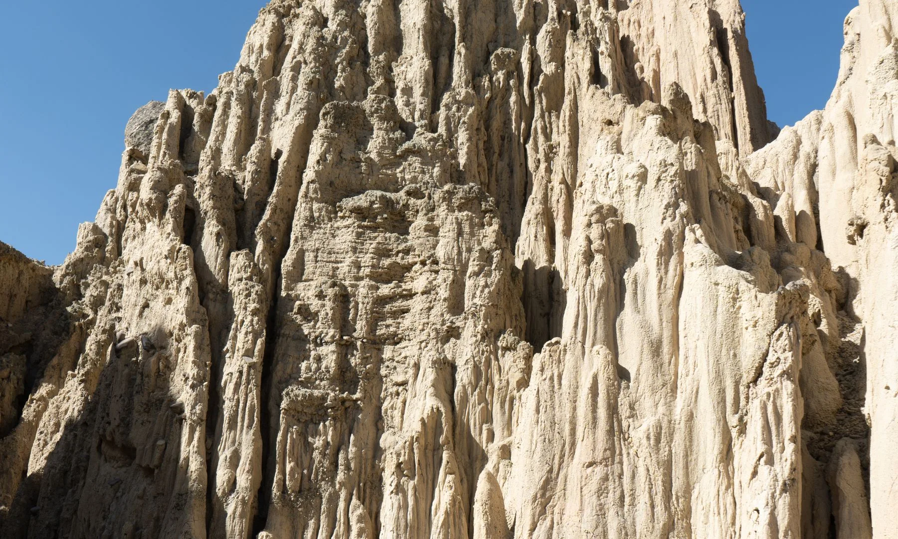 Stunning vertical rock formations under a clear blue sky at Valle de la Luna, Bolivia.
