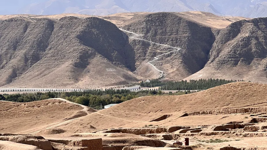Ruinas antiguas con colinas del desierto de Karakum al fondo bajo un cielo azul despejado