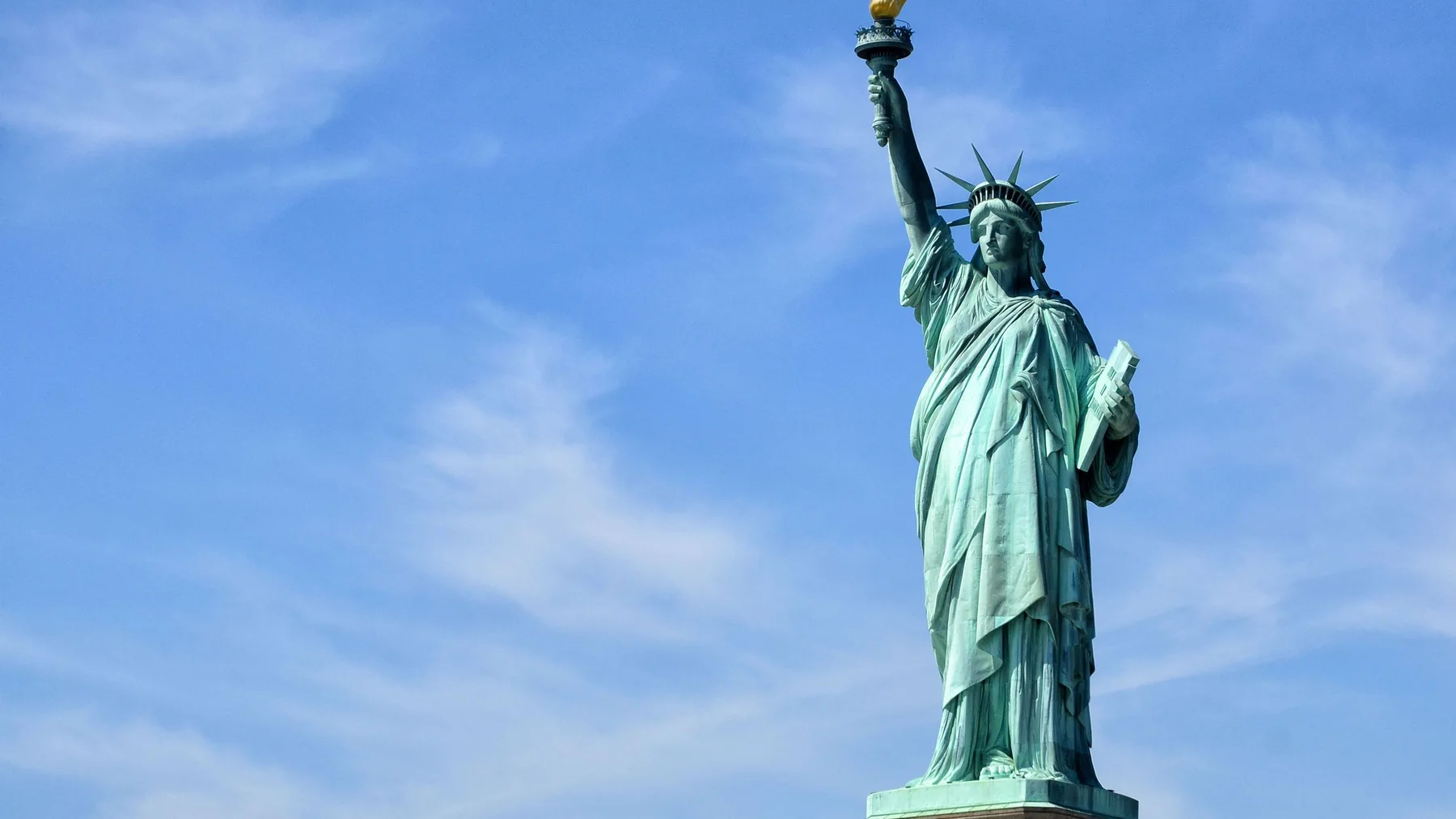 La Estatua de la Libertad se alza sobre Liberty Island bajo un cielo despejado