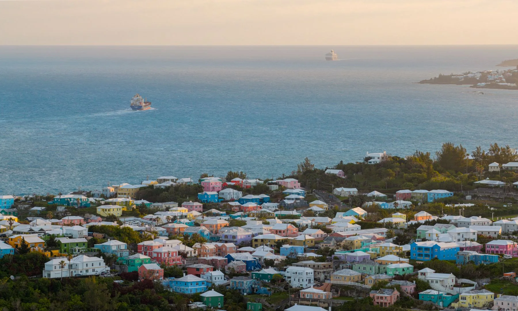 Stunning aerial view of Bermuda's colorful houses along the Atlantic Ocean at sunrise.