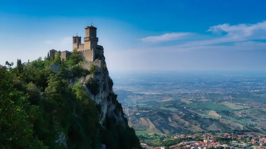 Castillo histórico de San Marino sobre un acantilado, con vistas al valle
