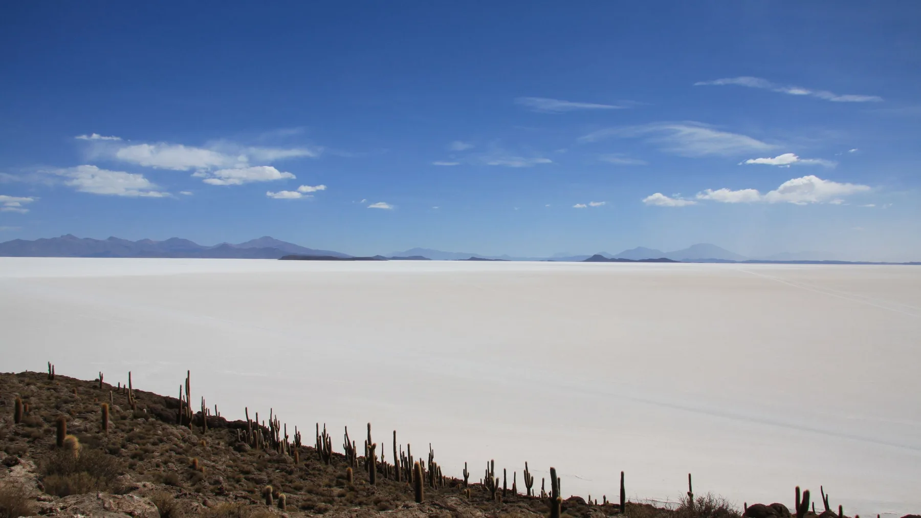 Breathtaking landscape of Salar de Uyuni with clear skies and distant mountains.