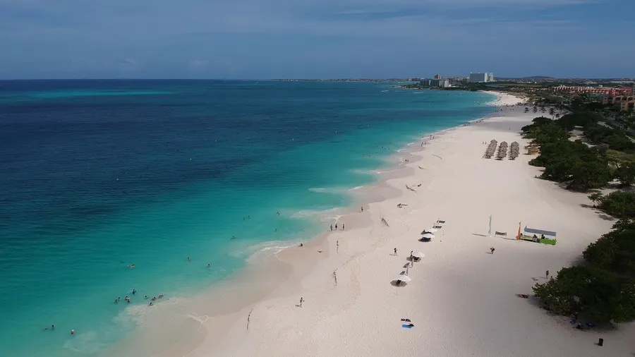 Vista aérea de una playa de arena blanca y aguas turquesas en Aruba