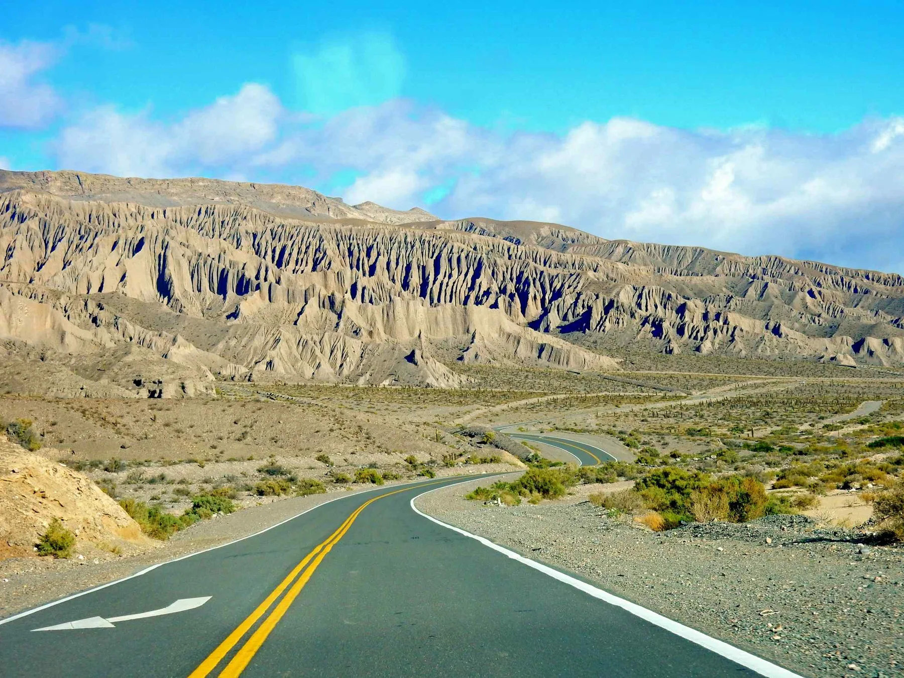Vista panorámica de cerros multicolores y la ruta RN51 en la Puna salteña, camino de San Antonio de los Cobres a Salta