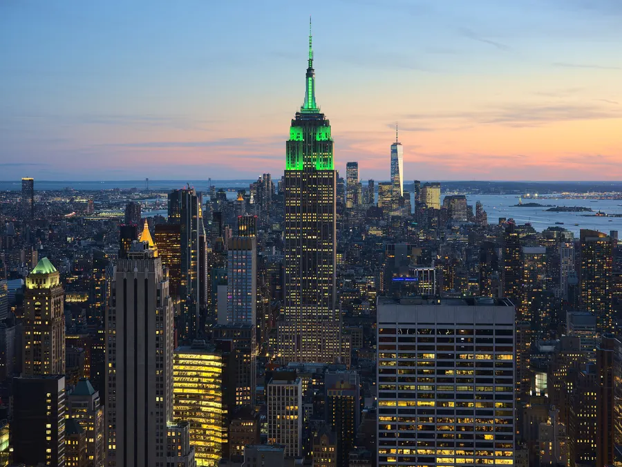Empire State Building iluminado en verde al atardecer, visto desde Top of the Rock en Rockefeller Plaza por Climate Week NYC
