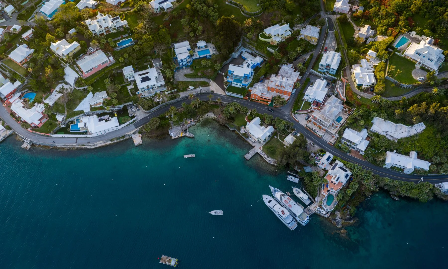 Stunning aerial photo capturing colorful coastal homes in Bermuda against the turquoise Atlantic Ocean.