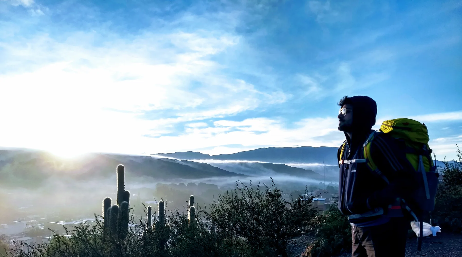 Amanecer sobre Humahuaca con cardones y un caminante en primer plano.