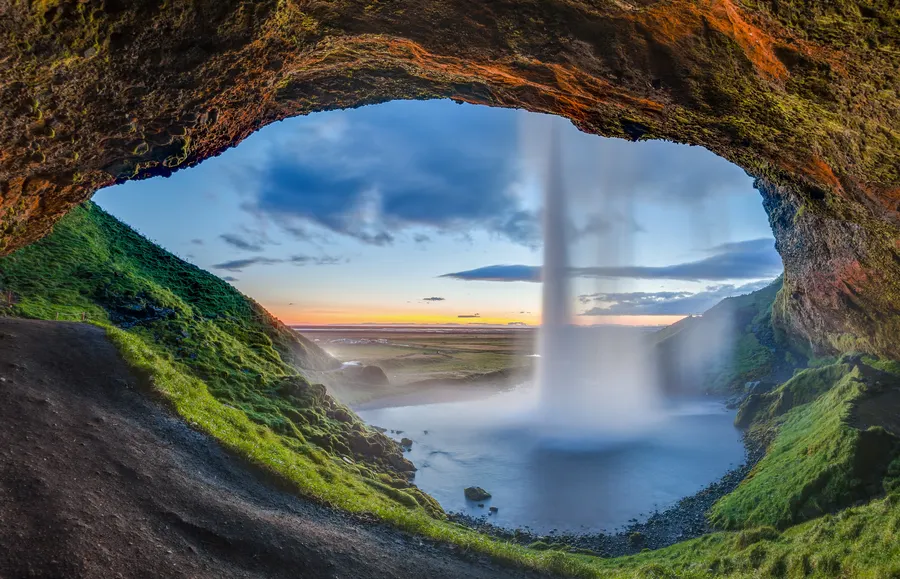 Vista al atardecer desde detrás de la cascada Seljalandsfoss, en Suðurland, Islandia
