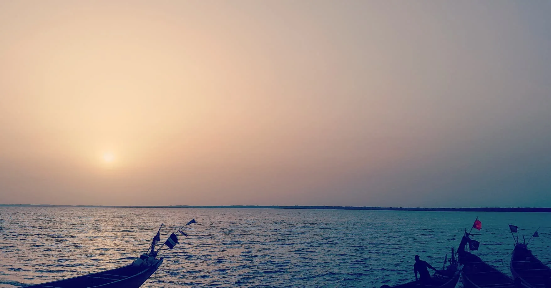 Atardecer sobre el río Cacheu, con luces de colores contrastando en el horizonte