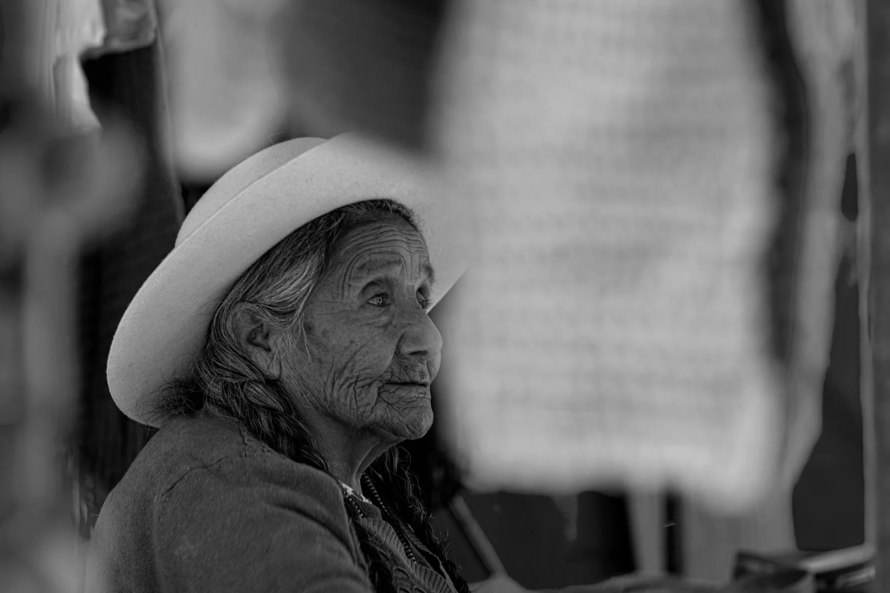 Retrato en blanco y negro de una mujer mayor con sombrero tradicional en un mercado de Salta, Argentina