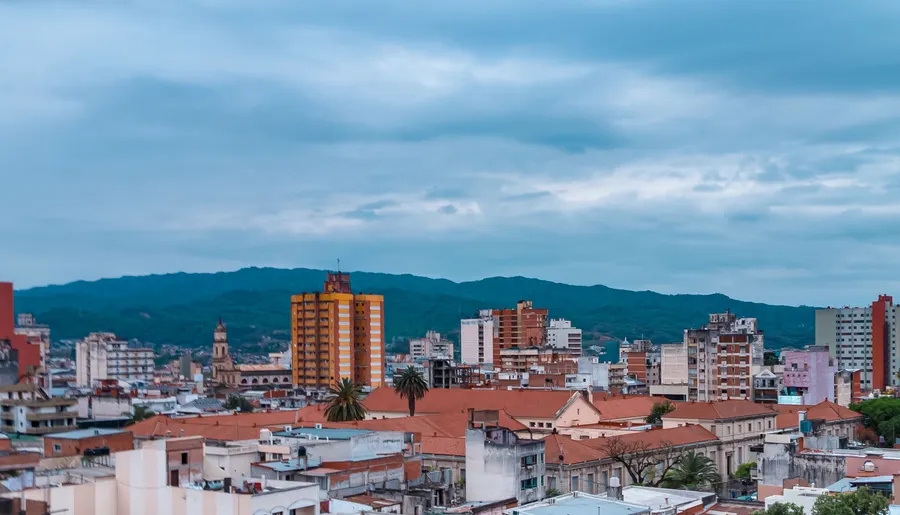 Urban cityscape of San Salvador de Jujuy, Argentina, showing buildings and mountains.