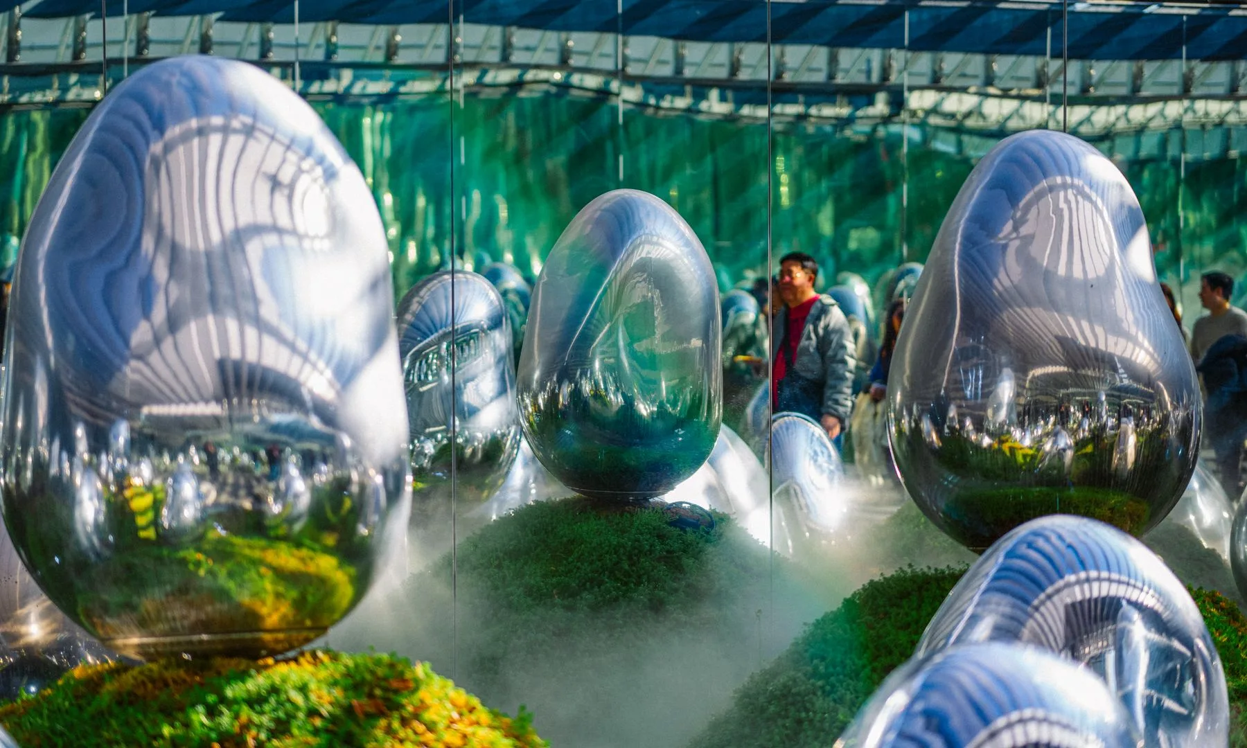 Instalación artística inmersiva con superficies espejadas, formas de huevo abstractas y niebla en teamLab Borderless, Tokio