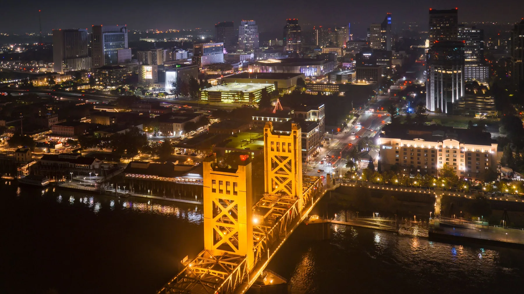 Stunning aerial view of Sacramento cityscape highlighting the illuminated Tower Bridge at night.