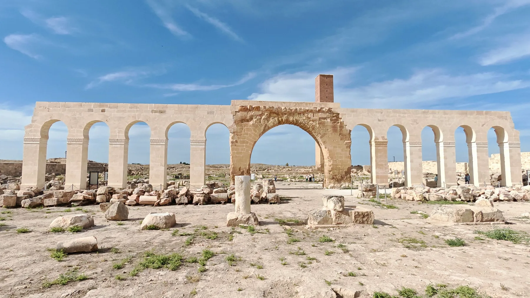 Arco y columnas de piedra antigua bajo un cielo azul despejado