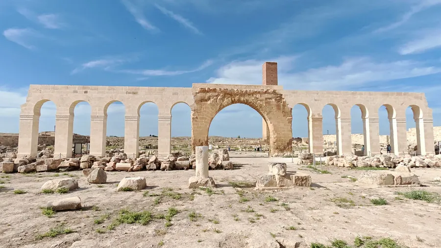 Arco y columnas de piedra antigua bajo un cielo azul despejado