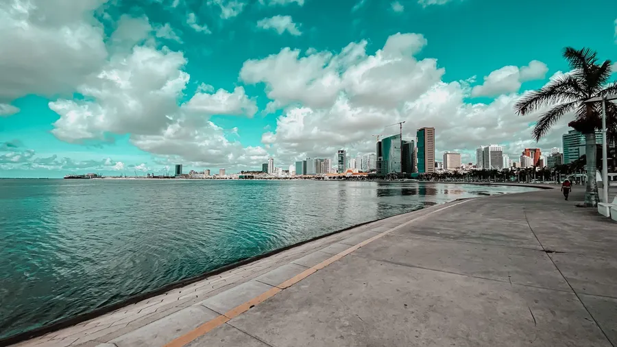 Vista de la bahía de Luanda, Angola, con nubes y reflejo del perfil urbano en el agua