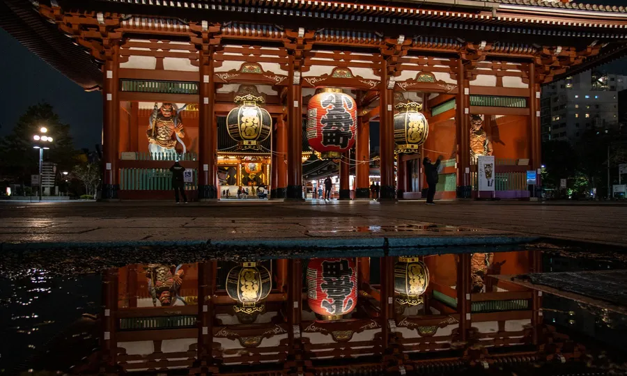 Templo Sensō-ji de Tokio de noche, reflejado en un charco