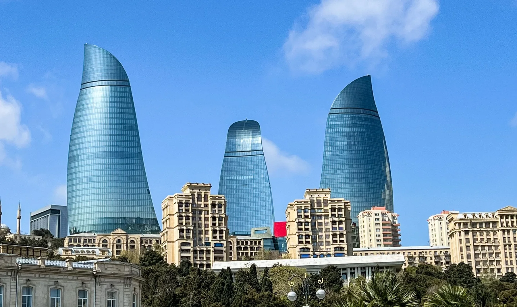 Las Torres de la Llama de Bakú se elevan sobre la ciudad, entre arquitectura moderna y vegetación