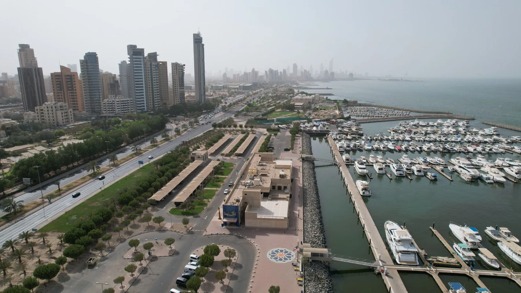 Vista aérea del horizonte moderno de Ciudad de Kuwait y su puerto concurrido con yates