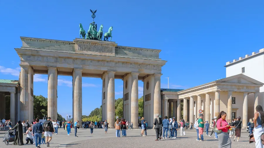 La Puerta de Brandeburgo en Berlín, rodeada de vida urbana bajo un cielo despejado