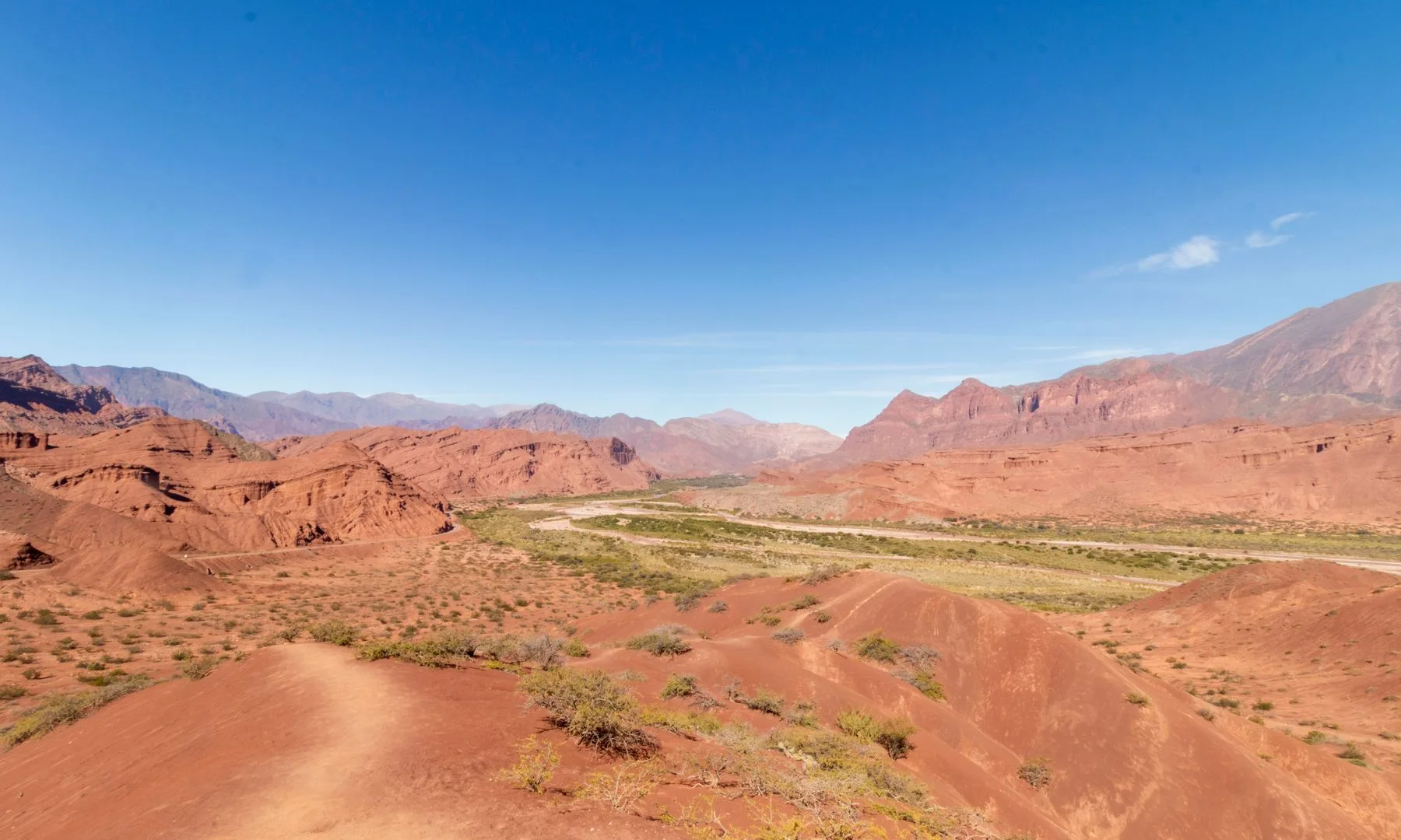Formaciones de roca rojiza y paisaje desértico en Cafayate, Salta, con cerros y valle de altura