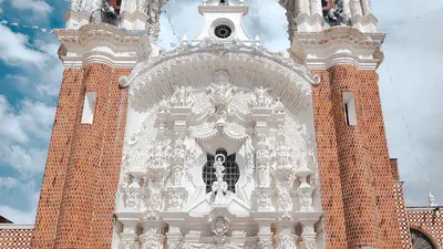Iglesia barroca de fachada intrincada bajo un cielo luminoso en Tlaxcala, México
