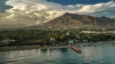 Vista aérea de la costa de Marbella con vegetación y montañas al fondo