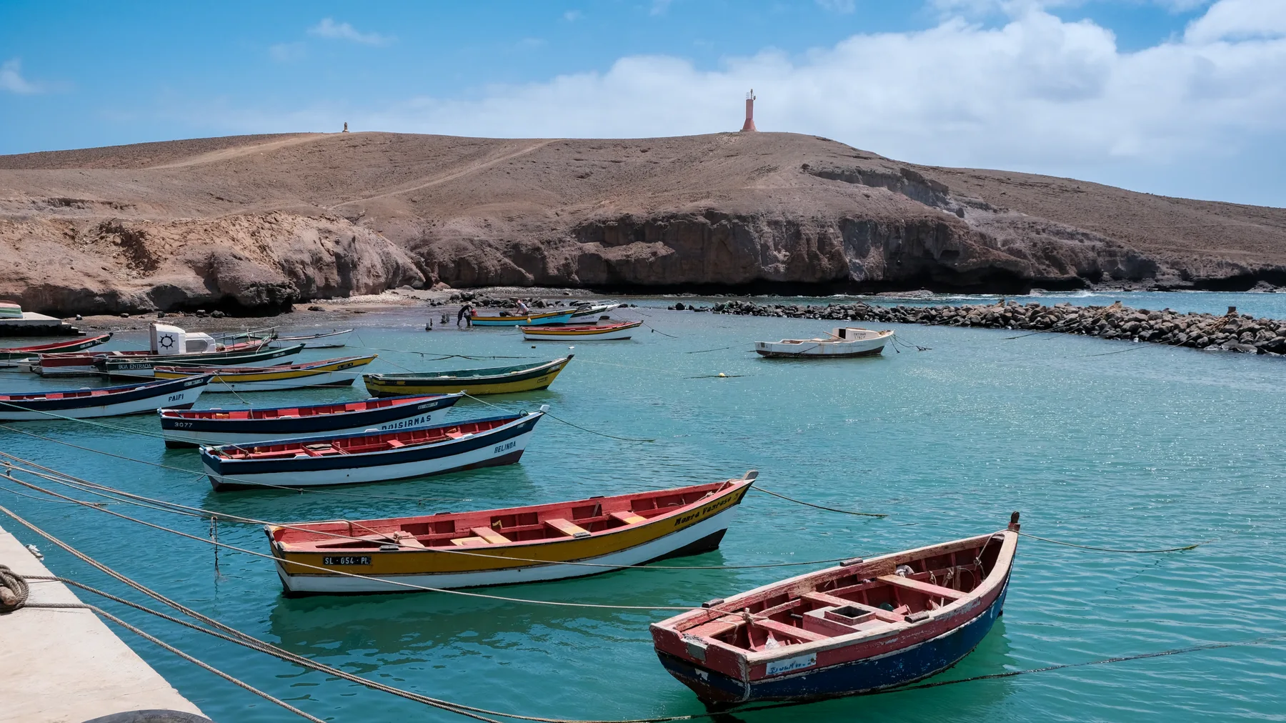 Botes pesqueros coloridos anclados en aguas tranquilas de Pedra Lume, Sal, Cabo Verde