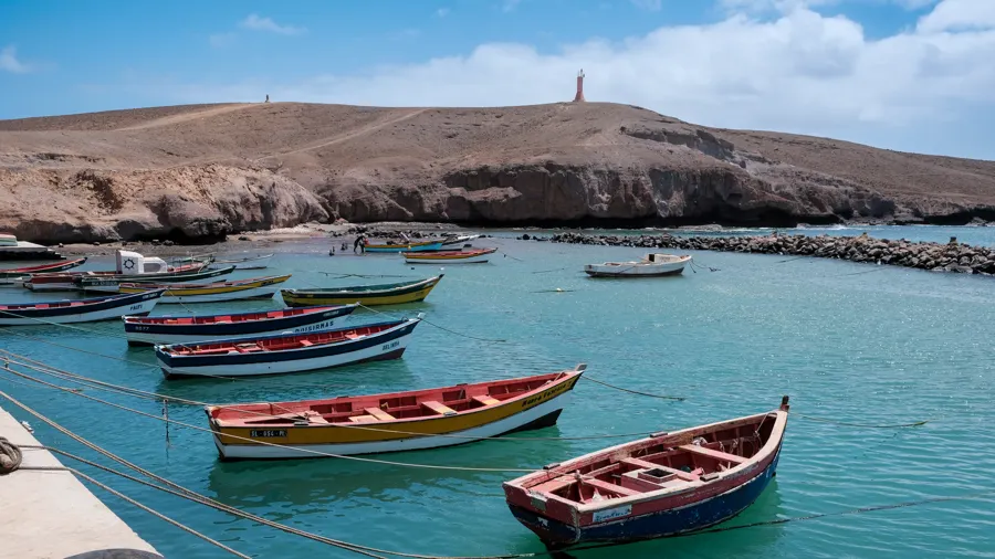 Botes pesqueros coloridos anclados en aguas tranquilas de Pedra Lume, Sal, Cabo Verde