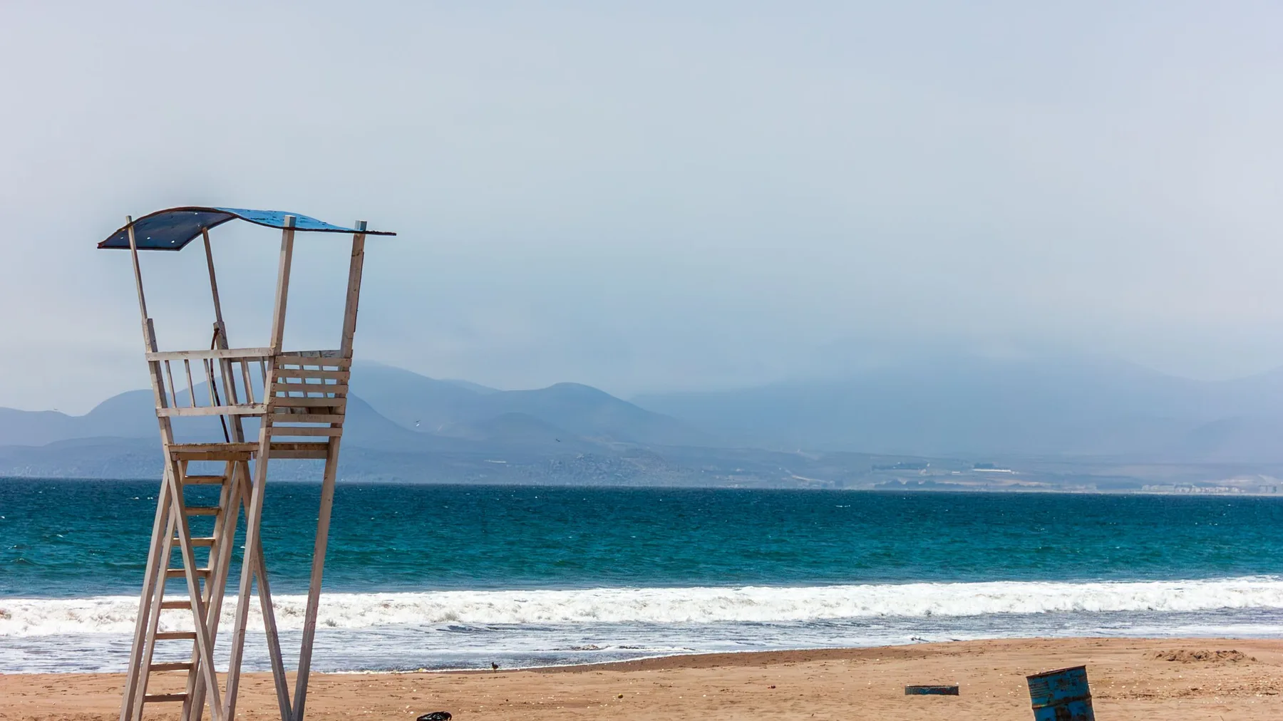 Playa tranquila con un puesto de salvavidas vacío y olas en La Serena, Chile
