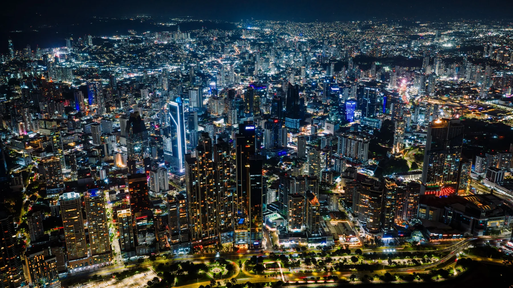 Vista aérea nocturna del horizonte de Ciudad de Panamá, con rascacielos iluminados y trama urbana extensa