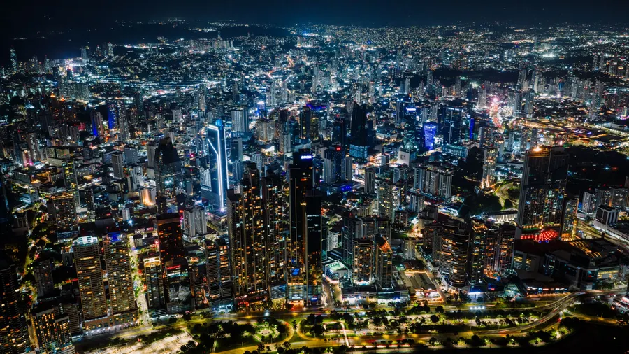 Vista aérea nocturna del horizonte de Ciudad de Panamá, con rascacielos iluminados y trama urbana extensa