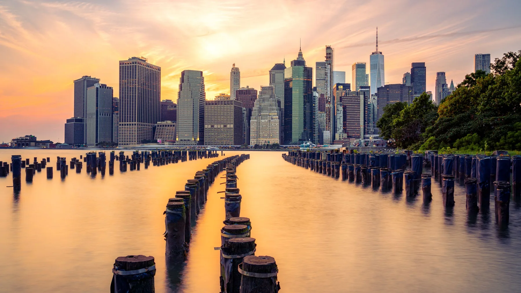 Scenic view of Manhattan skyline at sunset, seen from Brooklyn Bridge Park, New York City.