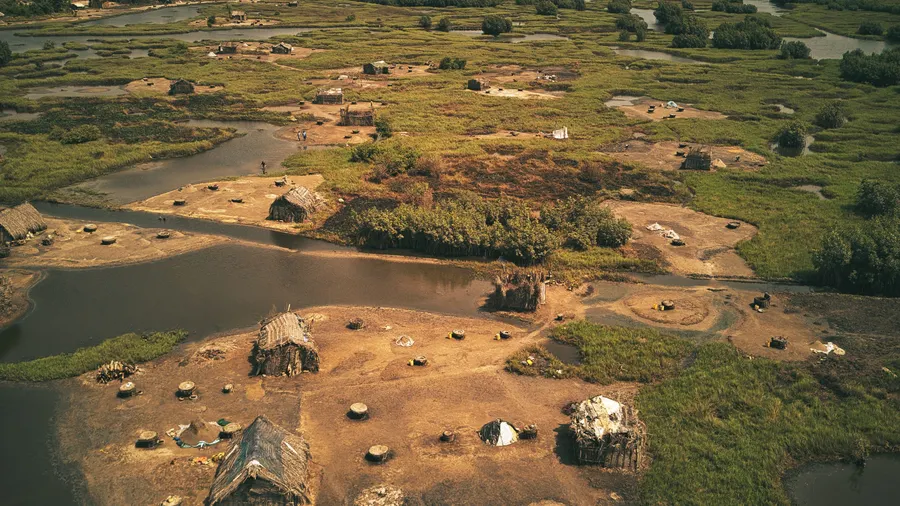 Vista aérea de chozas tradicionales y paisaje exuberante en Ouidah, Benín