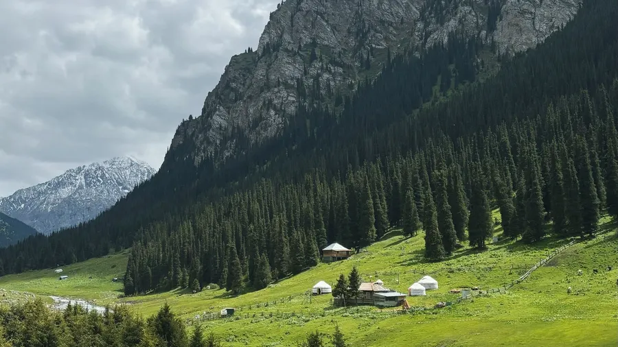 Paisaje montañoso de Altynarasan, Kirguistán, con yurtas en primer plano