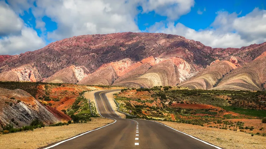 Winding road through vibrant landscapes and colorful mountains in Jujuy, Argentina.