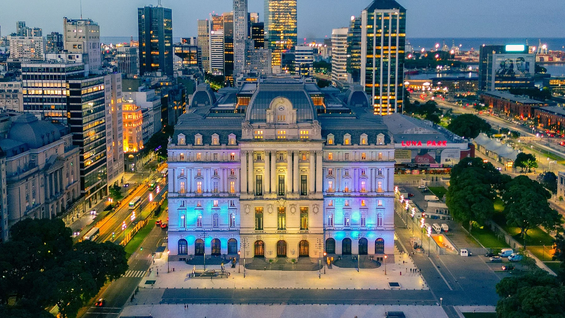Vista aérea nocturna de la Ciudad de Buenos Aires con un palacio iluminado entre los edificios