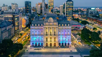Vista aérea nocturna de la Ciudad de Buenos Aires con un palacio iluminado entre los edificios