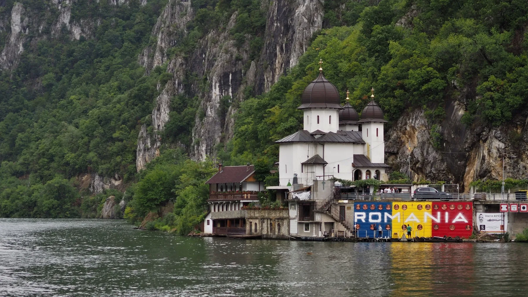 Iglesia ortodoxa junto al Danubio con montañas al fondo, en Rumanía