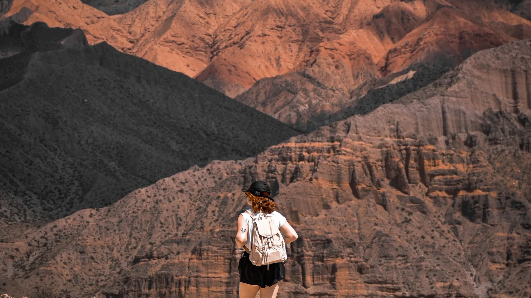 Mujer caminando junto a su perro por los paisajes de Tilcara, Jujuy, Argentina