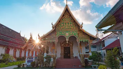 Fachada ornamentada del templo Wat Chiang Man en Tailandia, con un motivo de sol radiante y arquitectura tradicional tailandesa