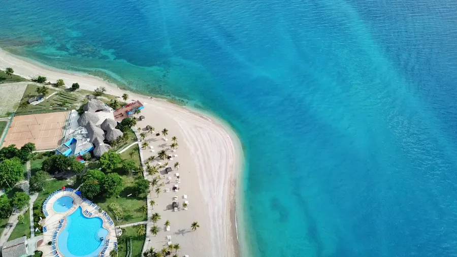 Vista aérea de un resort de playa tropical en Haití con piscina y aguas turquesas