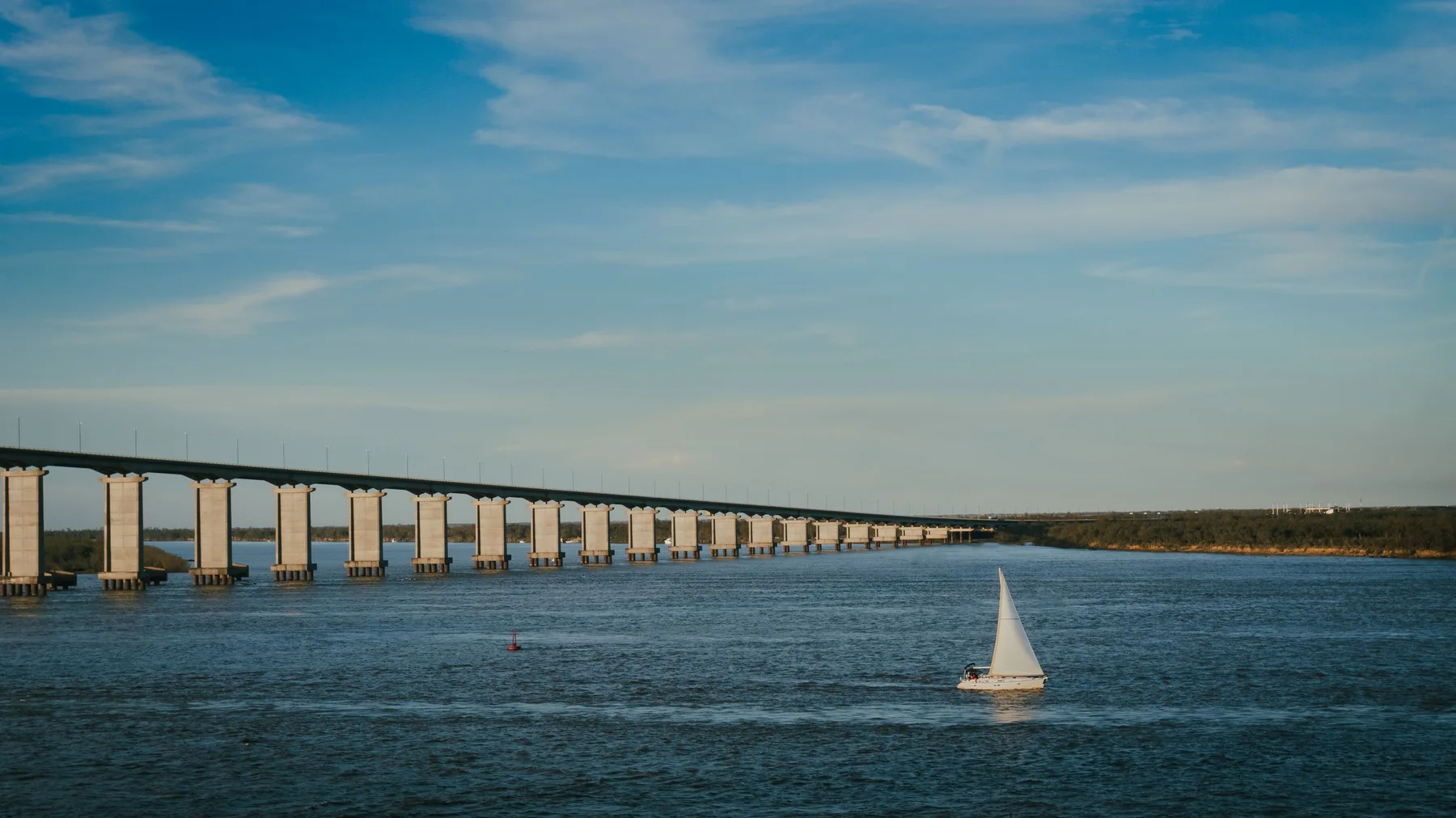 Velero navegando bajo el Puente Rosario-Victoria durante una tarde pintoresca en Rosario, Argentina