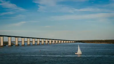 Velero navegando bajo el Puente Rosario-Victoria durante una tarde pintoresca en Rosario, Argentina