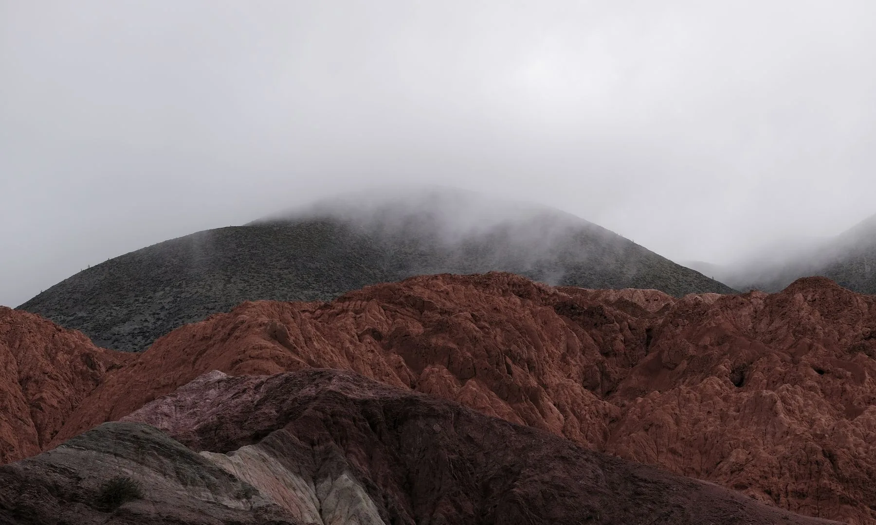 Vista de los cerros multicolores de Purmamarca entre la bruma, en la Quebrada de Humahuaca, Jujuy
